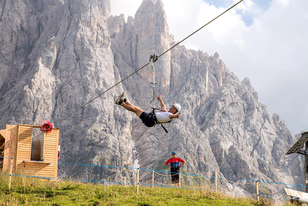 Un turista si diverte volando sulla ZiLine del Monte Pana