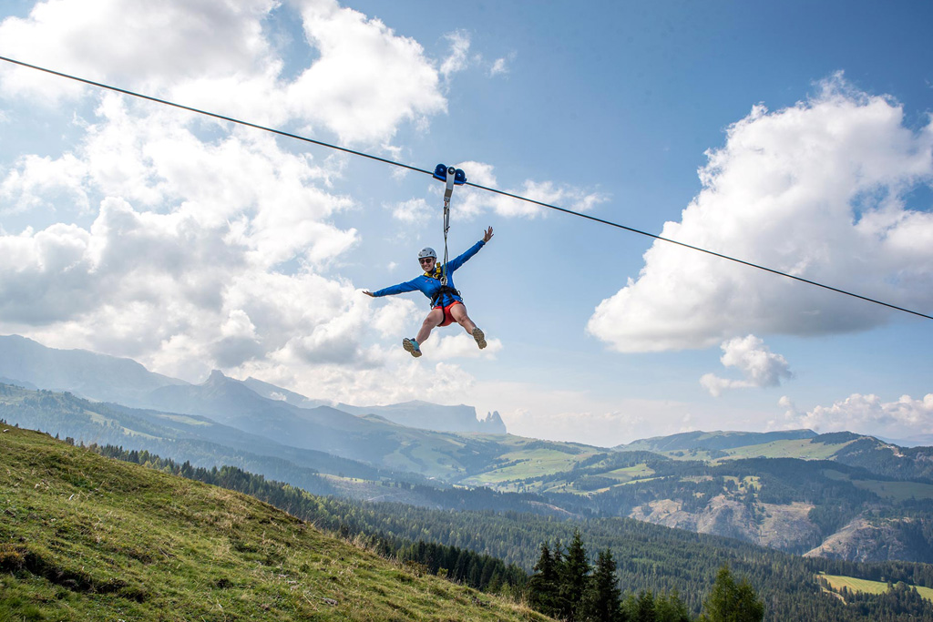 Una turista si diverte volando sulla ZiLine del Monte Pana
